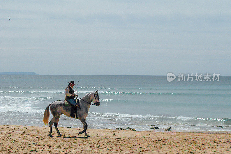 一名男子在西班牙安撒卢西亚自治社区的海滩上骑马