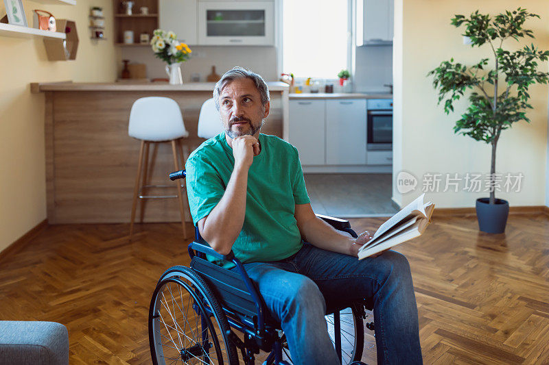 轮椅上的成熟男人在客厅里看书
