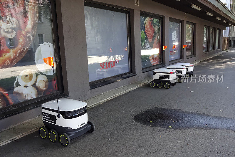 在Pelgulinna区，四台用于送餐的现代自动机器人Starship停在杂货店Selver附近等待