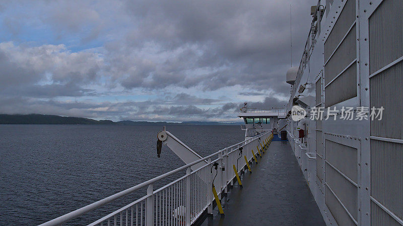 BC轮渡MV北伐船在秋日多云的一天经过卡尔弗特岛，甲板和金属栏杆都是空的。