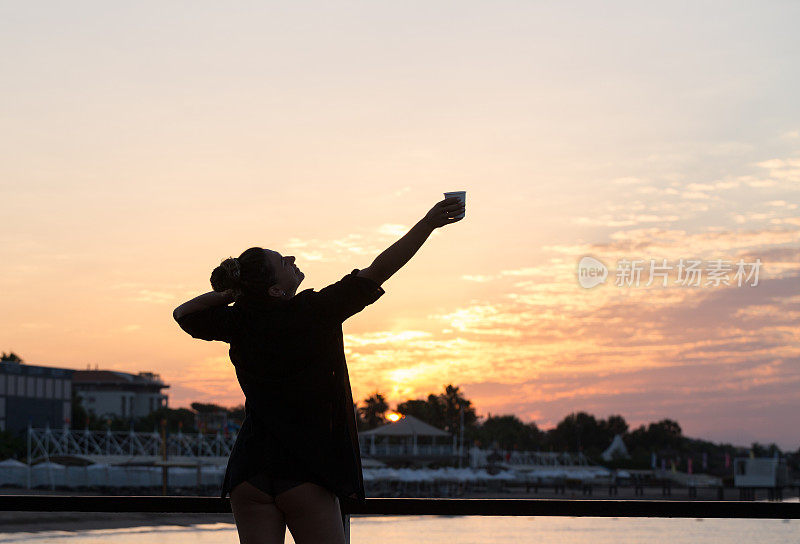 那位妇女喜欢在海边看日落。