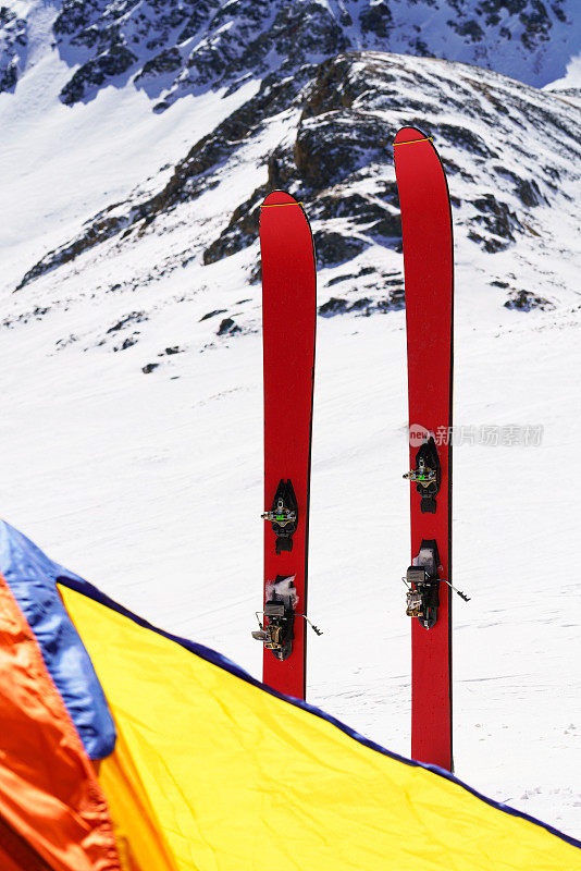 滑雪板和帐篷戏剧性陡峭的山背景