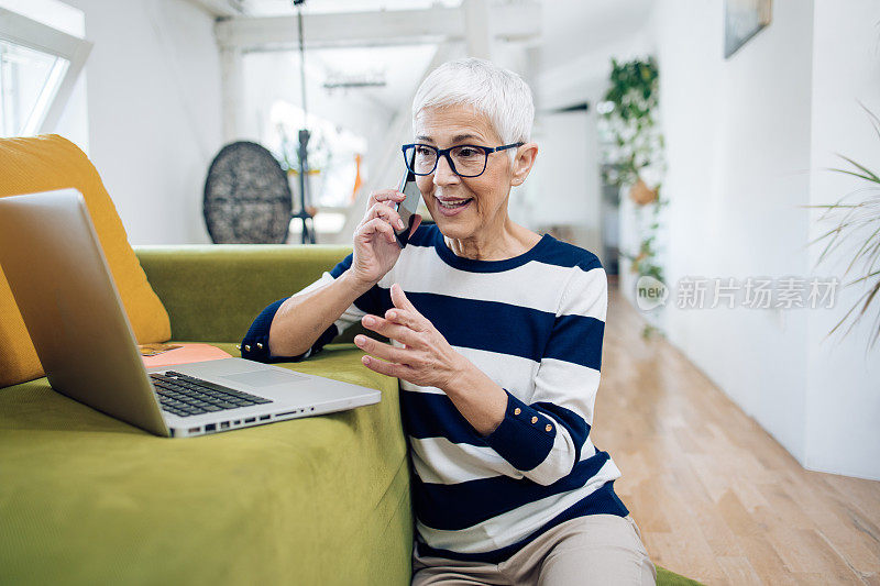 一位成熟的企业家在客厅打商务电话的肖像