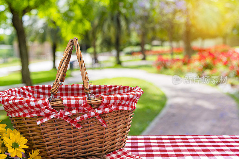 野餐篮子在桌子上与模糊的公共公园背景
