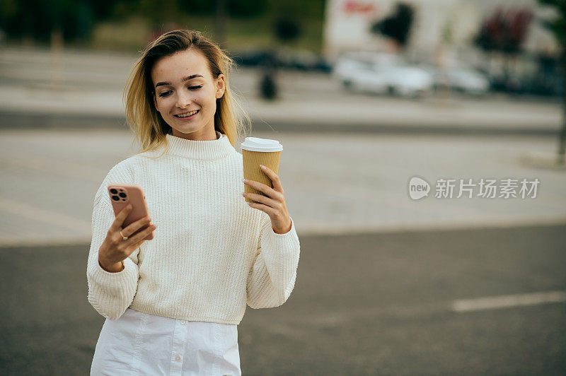 年轻女子晚上在街上用智能手机