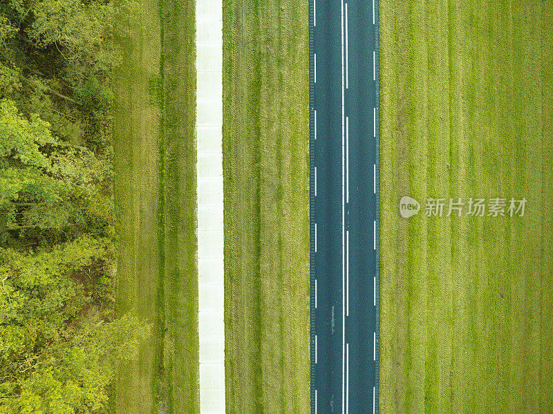 从上面看，一条笔直的路越过堤坝，旁边是一片森林