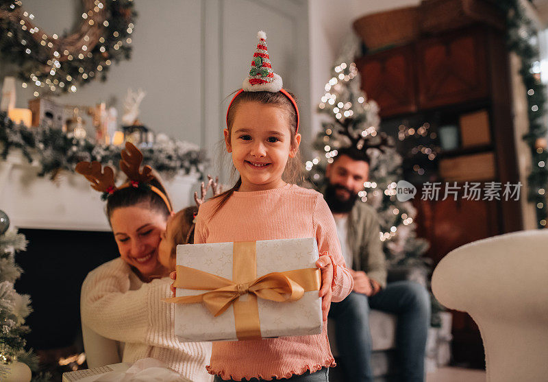 一个小女孩拿着圣诞礼物的画像
