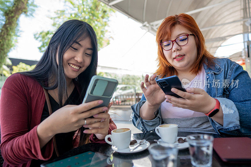日本女性朋友在咖啡馆使用智能手机