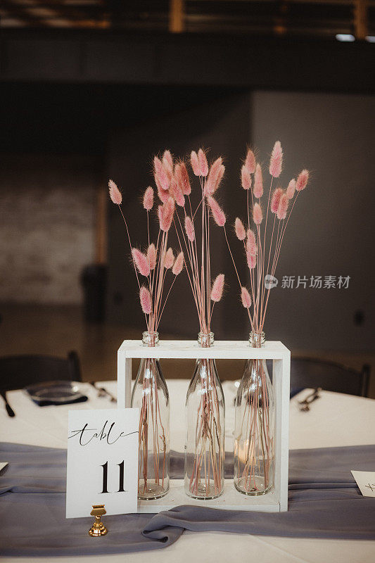粉红色茎和桌子号码的婚礼中心装饰品