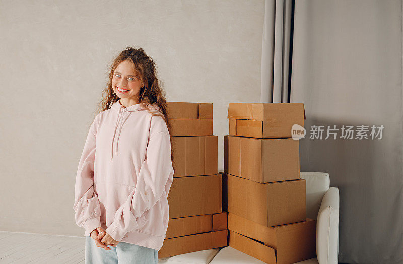 快乐的年轻女子肖像与纸板箱移动到新的房地产家庭公寓。