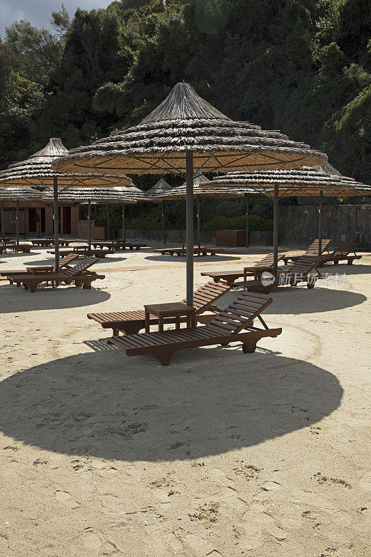 沙滩上的竹伞和木制甲板