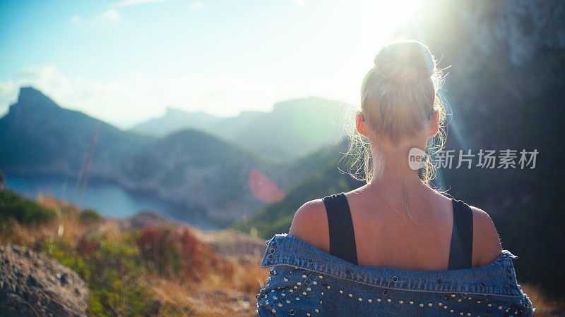 在山上徒步旅行的女游客。在炎热的夏日享受美丽的风景