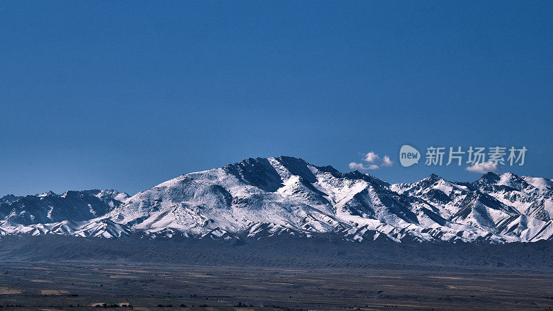 积雪覆盖的山脊在较低的山脉后面。南天山，贾拉拉巴德地区，吉尔吉斯斯坦