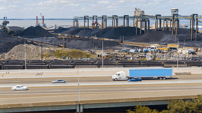 煤炭被堆放在纽波特纽斯的工业港口，弗吉尼亚州港口的煤炭码头。卡车驶过港口。鸟瞰图
