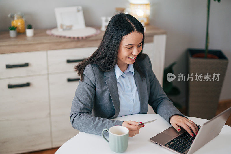 漂亮的年轻女子在家里用笔记本电脑网购