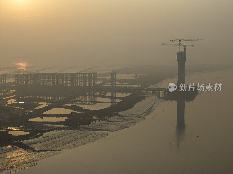 日出时在建跨海大桥的航拍照片