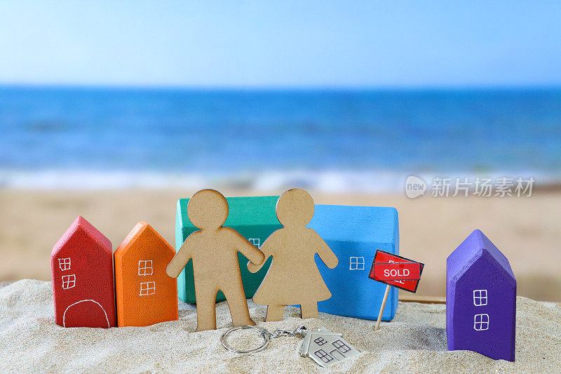 木雕异性恋夫妇的形象，组彩虹木制模型度假小屋在沙滩上，红色，橙色，绿色，浅蓝色，紫色，沙滩背景与海浪在低潮，大海和海岸线，度假出租，度假屋的概念