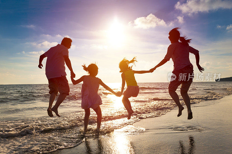 快乐的一家人一起在海滩上跳跃