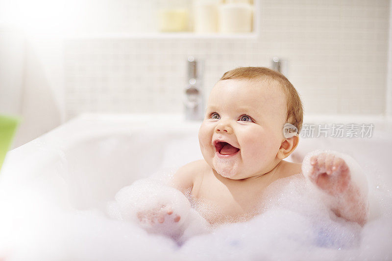 小男孩在他的泡泡浴里笑