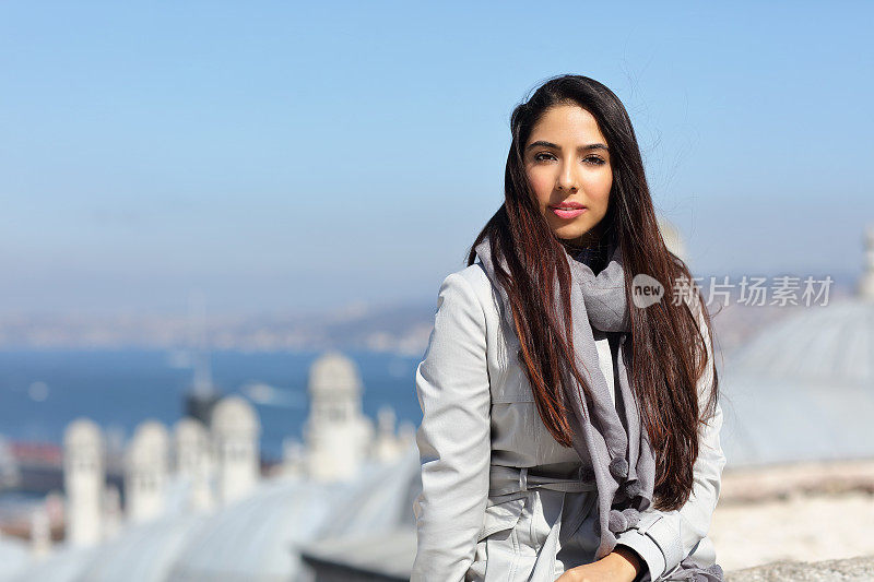 美丽的女人坐在外面的苏莱曼清真寺享受土耳其伊斯坦布尔的惊人的景色