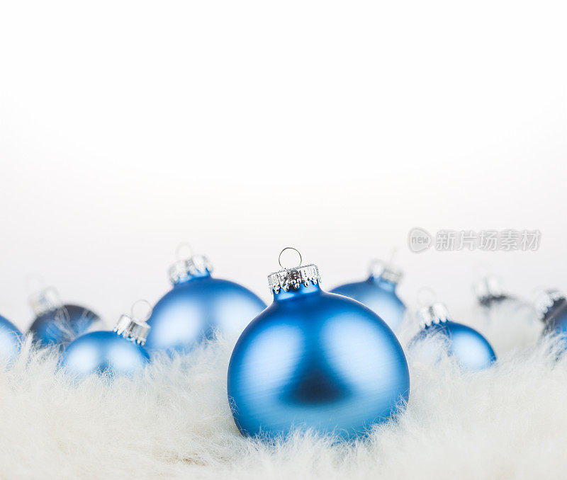 蓝色的圣诞球在松软的雪地上
