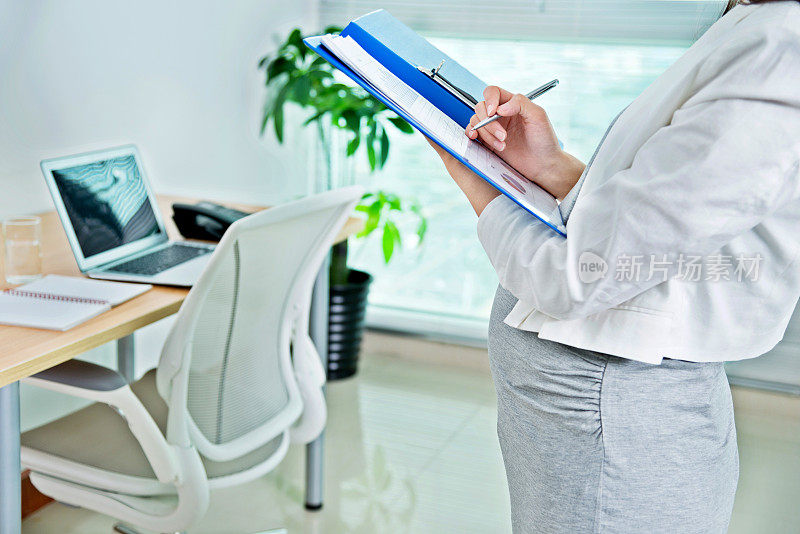 孕妇在活页夹里写作