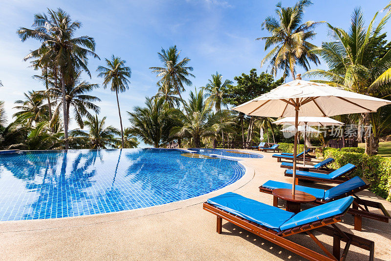 美丽的热带海滨度假酒店配有游泳池，阳光明媚