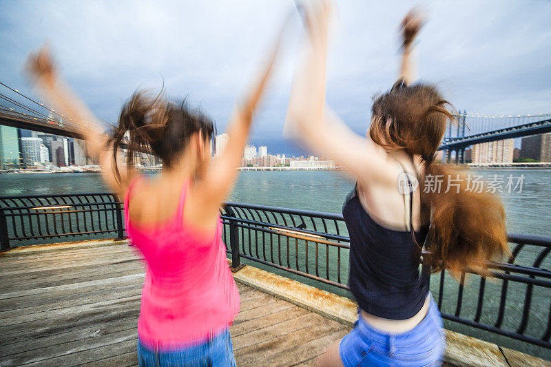 两个女孩，姐妹，在暴风雨中看着曼哈顿
