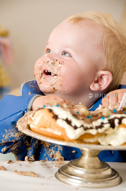 快乐的男孩庆祝生日，吃了一个大蛋糕