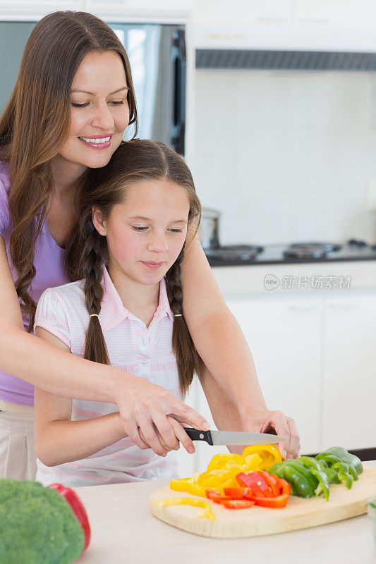 女人和女儿在厨房切菜