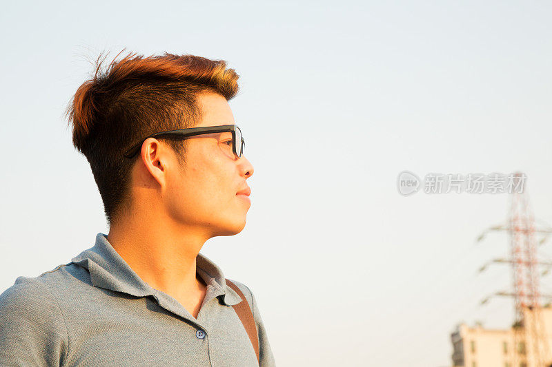 自信的年轻越南男子对蓝天的轮廓