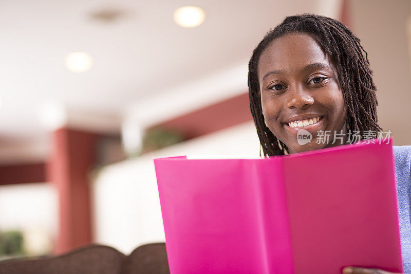 非洲裔少女在家里读书。