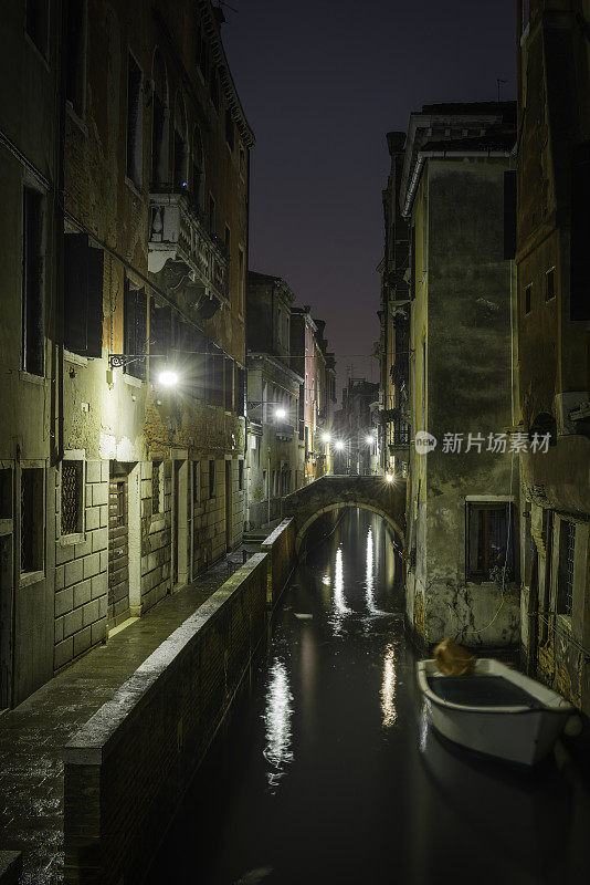 威尼斯的灰泥联排别墅俯瞰意大利夜晚宁静的运河