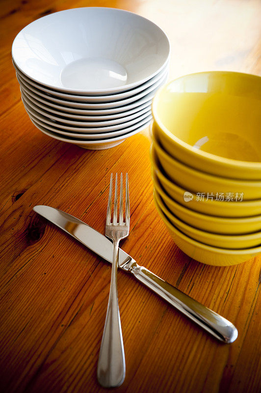 厨房桌子上堆放着银餐具的碗。
