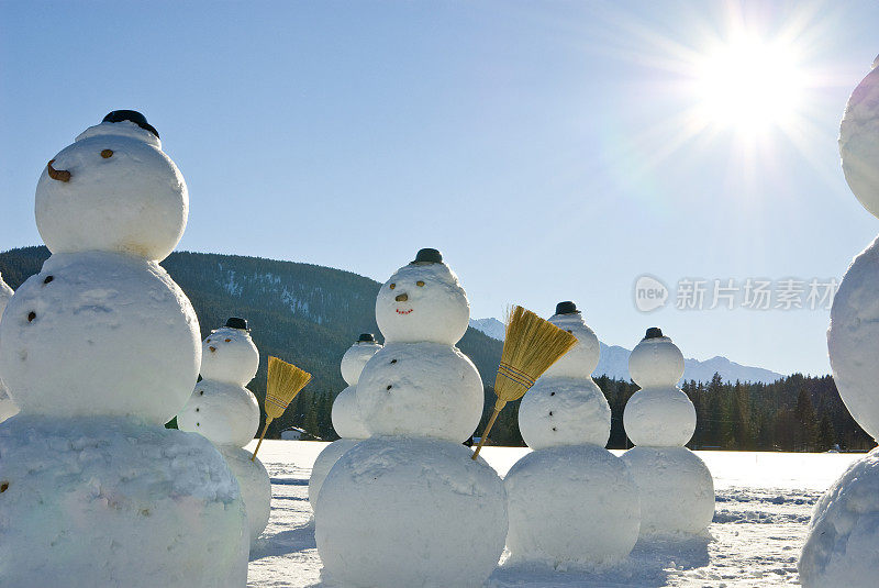 雪人军队-雪人戴着帽子和扫帚在太阳