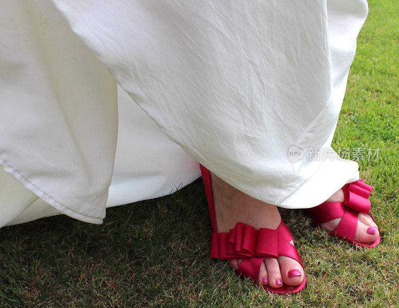 新娘穿着白色的婚纱和粉色的鞋子