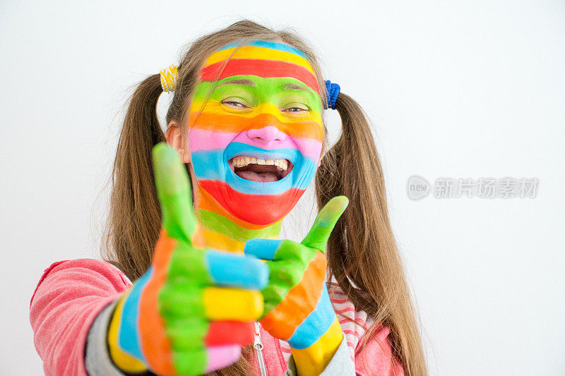 年轻微笑的女人与艺术化妆在彩虹的颜色显示OK标志