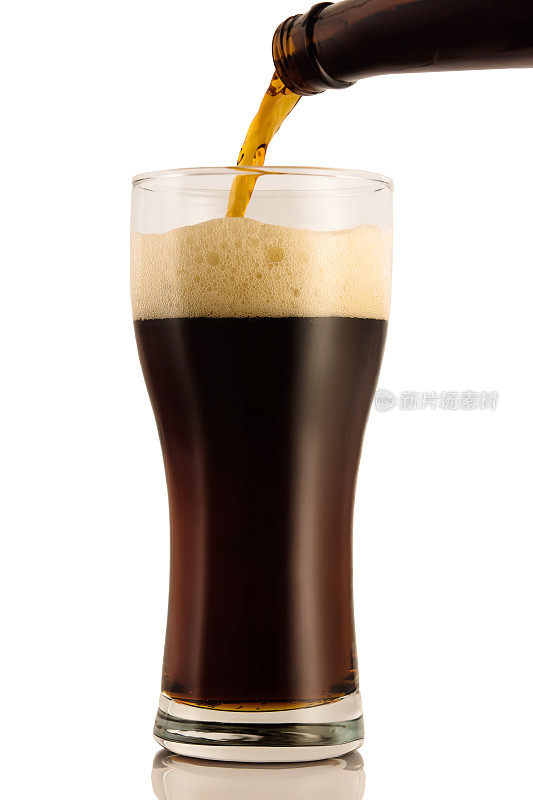 黑啤酒从瓶子里倒进玻璃杯里，孤立在白色的背景上