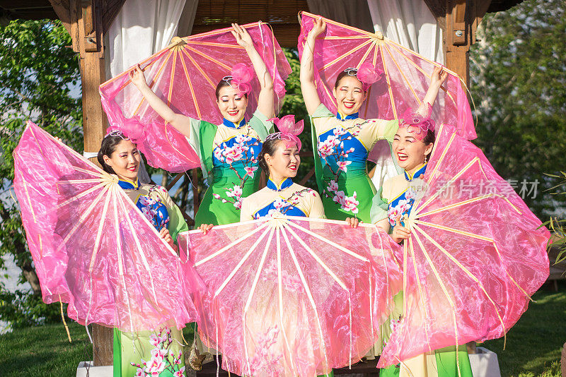 五名亚洲女演员身着中国传统服装，与粉丝们在户外