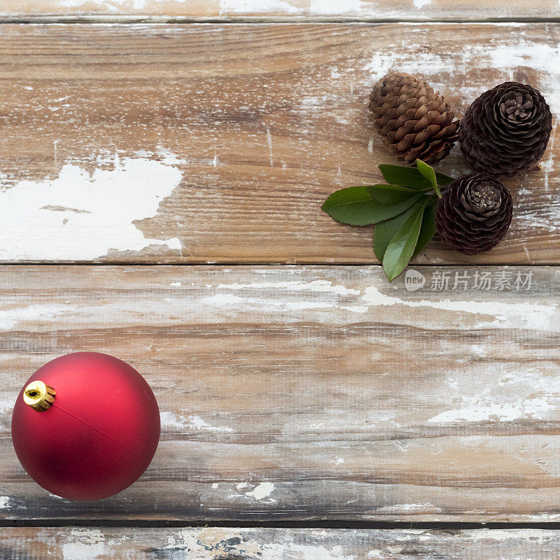 木头桌子上放着圣诞装饰物和松果
