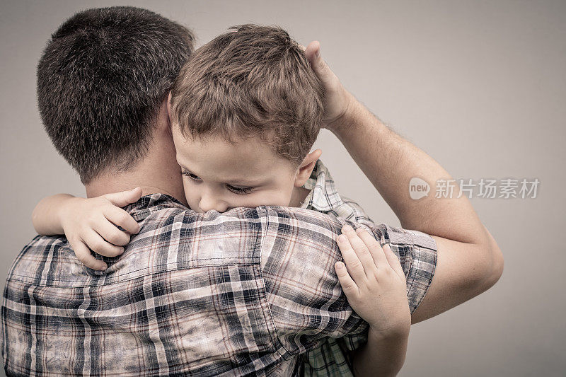 悲伤的儿子拥抱他的父亲