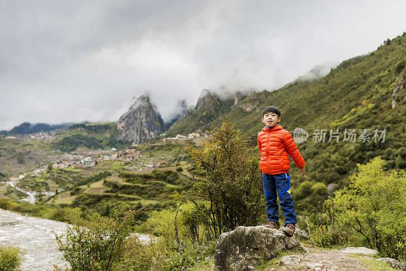 小男孩站在山顶上