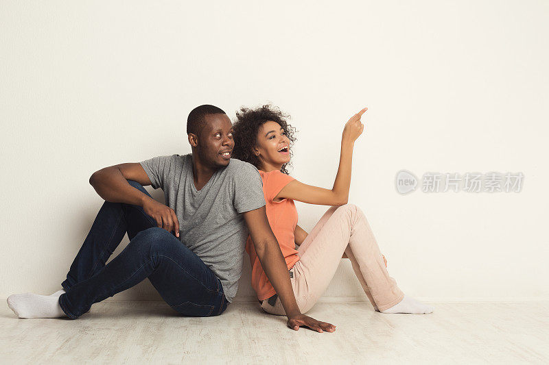 一对黑人夫妇坐在地板上抬头看
