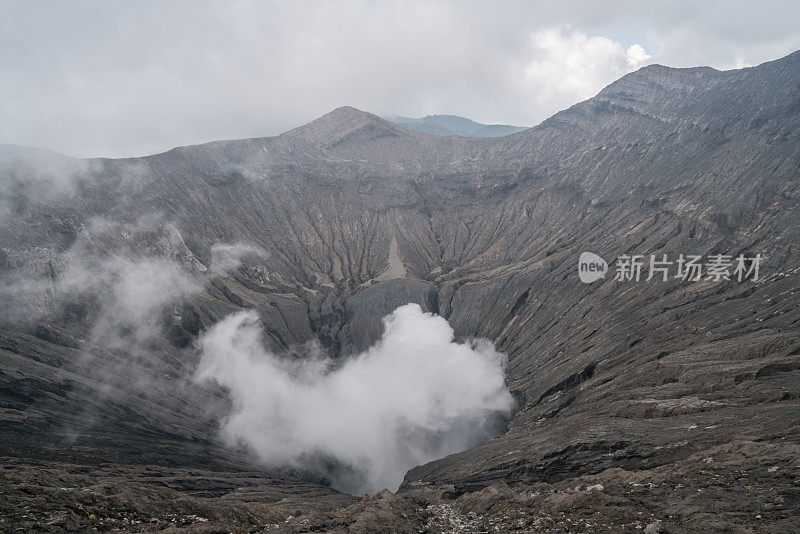 在印度尼西亚东爪哇岛的布罗莫山国家公园，布罗莫火山口边缘有蒸汽。旅游目的地冒险的自然概念