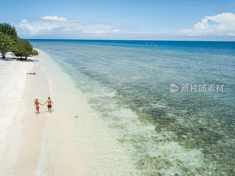 鸟瞰热带海滩上的年轻情侣享受度假和大自然，人们旅游探险的理念