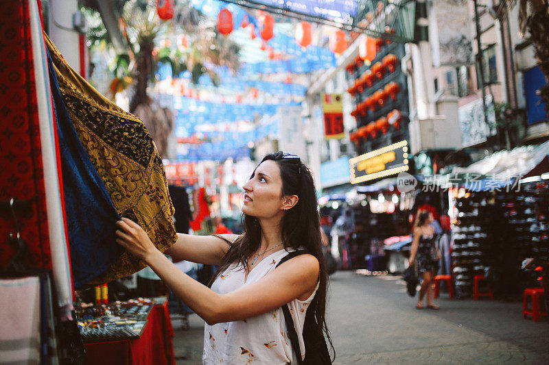 年轻的旅行者女人在吉隆坡唐人街区购物