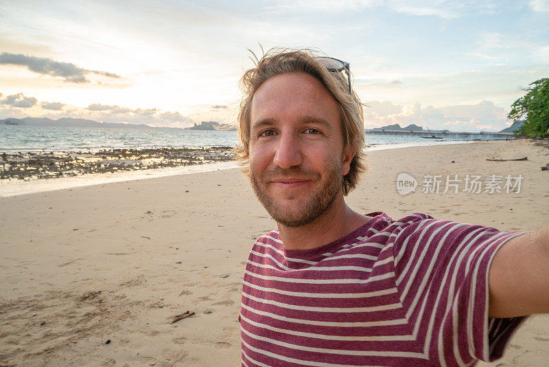一名年轻人在泰国海滩上自拍。人们旅行豪华度假乐趣和酷的态度概念