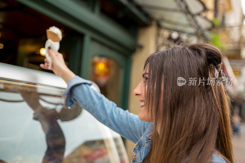 一名女子在糕点美食家的市场小摊上购买传统冰淇淋