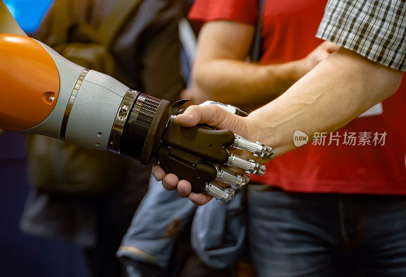 一个男人和一个机器人握手的手。