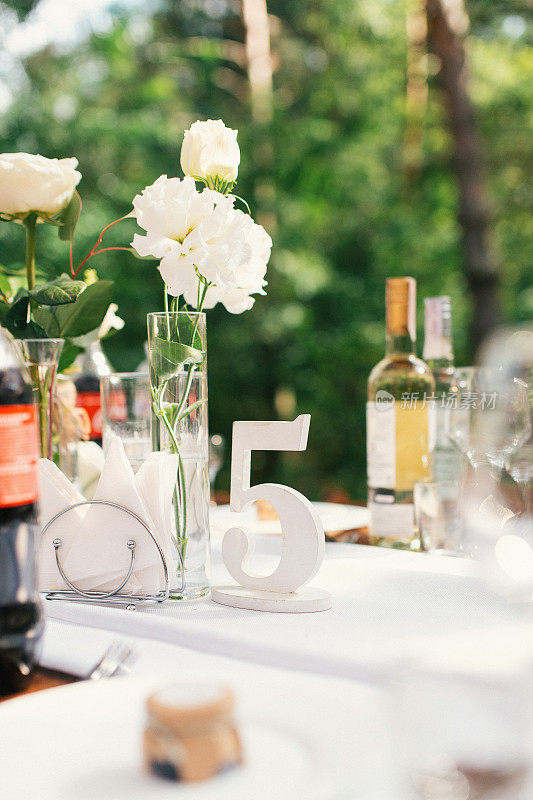 高雅的婚宴餐桌布置、花卉装饰、餐厅。婚礼表设置。森林婚礼。座位号码。